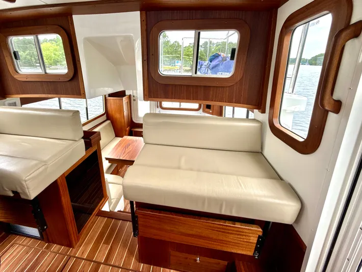 Blue Wander Yacht Photos Pics Interior of 2023 Nordic Tug 34, featuring wood accents and cream seating.