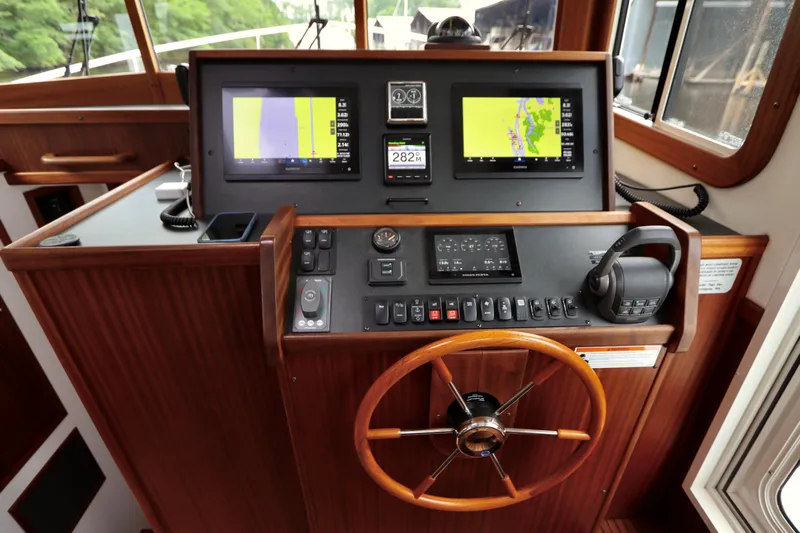 Blue Wander Yacht Photos Pics 2023 Nordic Tug 34 Tug helm with dual navigation screens and wooden steering wheel.