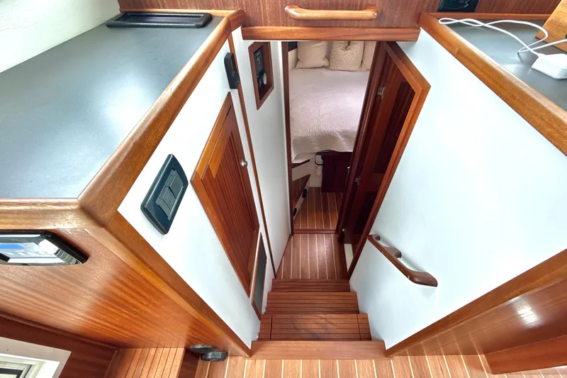 Blue Wander Yacht Photos Pics Interior view of 2023 Nordic Tug 34, featuring wooden stairs and cozy cabin.