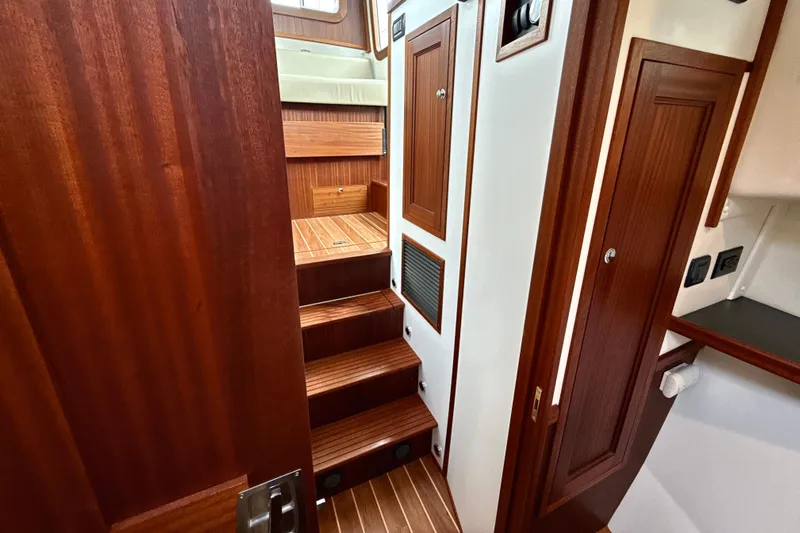 Blue Wander Yacht Photos Pics Interior of 2023 Nordic Tug 34, featuring wooden stairs and cabinetry.