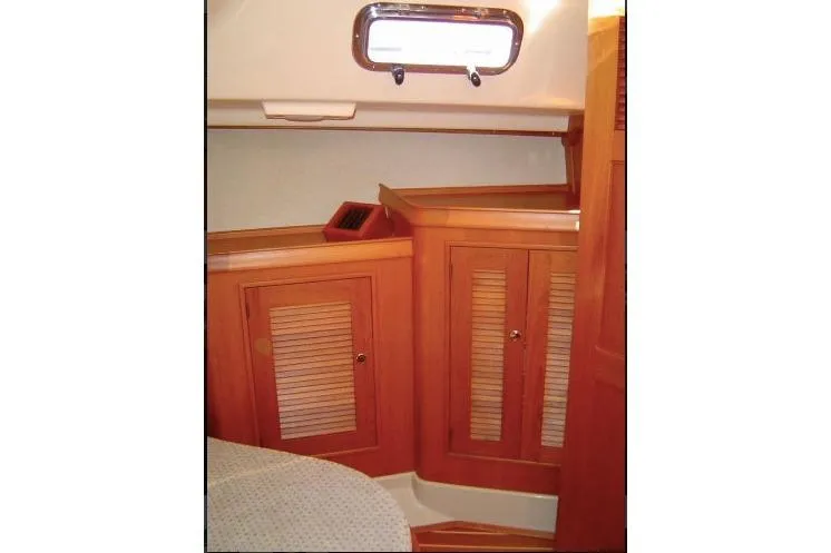 Navigator Yacht Photos Pics 2002 Island Packet Packet Craft Express 360 cabin interior with wooden cabinetry and porthole.