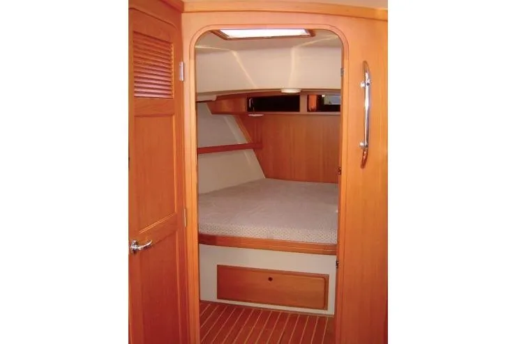 Navigator Yacht Photos Pics 2002 Island Packet Packet Craft Express 360 cabin interior with wooden finish and cozy bed.