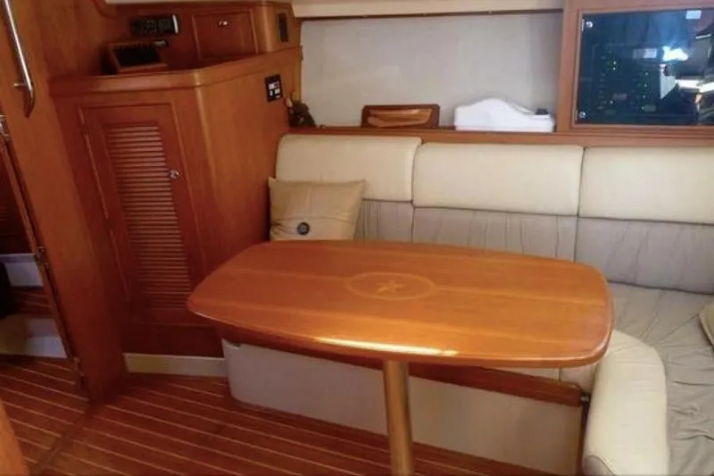 Navigator Yacht Photos Pics Interior of 2002 Island Packet Craft Express 360 with wooden table and cushioned seating.