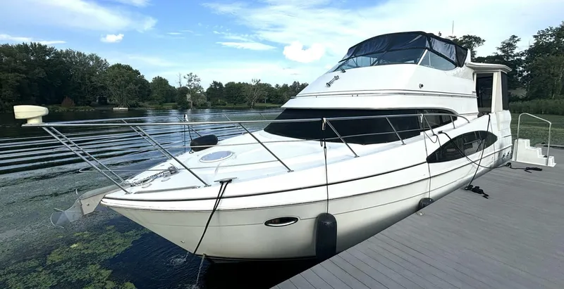  Yacht Photos Pics 2004 Carver 466 Motor Yacht docked on a serene lake with lush greenery.