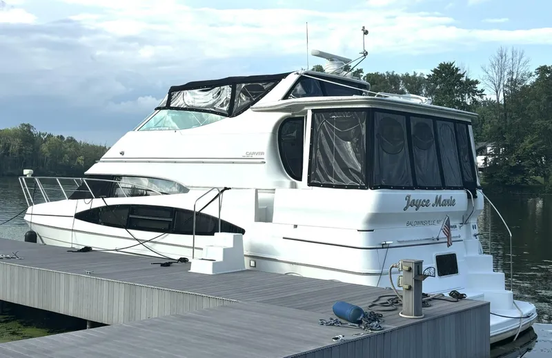  Yacht Photos Pics 2004 Carver 466 Motor Yacht docked by a serene lake with lush greenery.