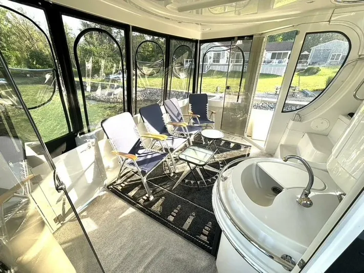  Yacht Photos Pics Luxurious 2004 Carver 466 Motor Yacht interior with seating and sink, featuring large windows.