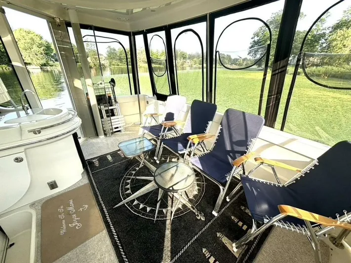  Yacht Photos Pics Interior of 2004 Carver 466 Motor Yacht with chairs and table, overlooking water and greenery.