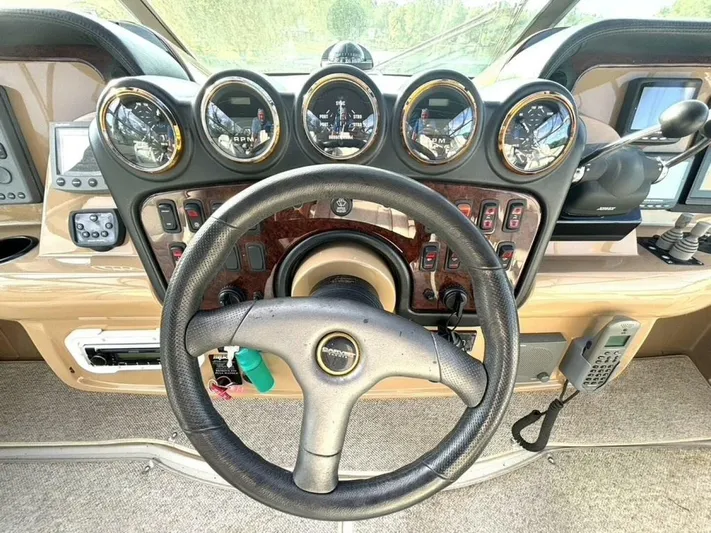  Yacht Photos Pics Steering wheel and dashboard of a 2004 Carver 466 Motor Yacht, featuring multiple gauges and controls.