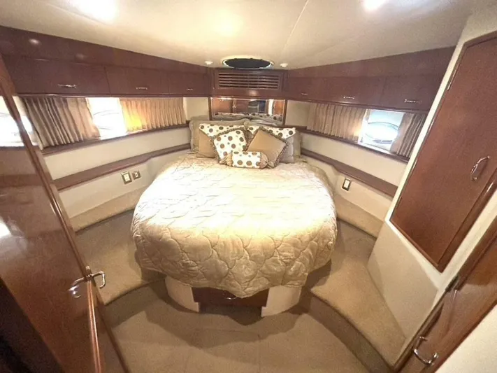  Yacht Photos Pics Luxurious bedroom interior of 2004 Carver 466 Motor Yacht with elegant bedding and wood cabinetry.