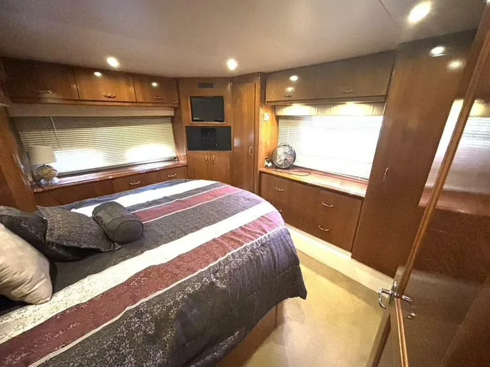  Yacht Photos Pics Luxurious bedroom interior of 2004 Carver 466 Motor Yacht with wood cabinetry and cozy bedding.