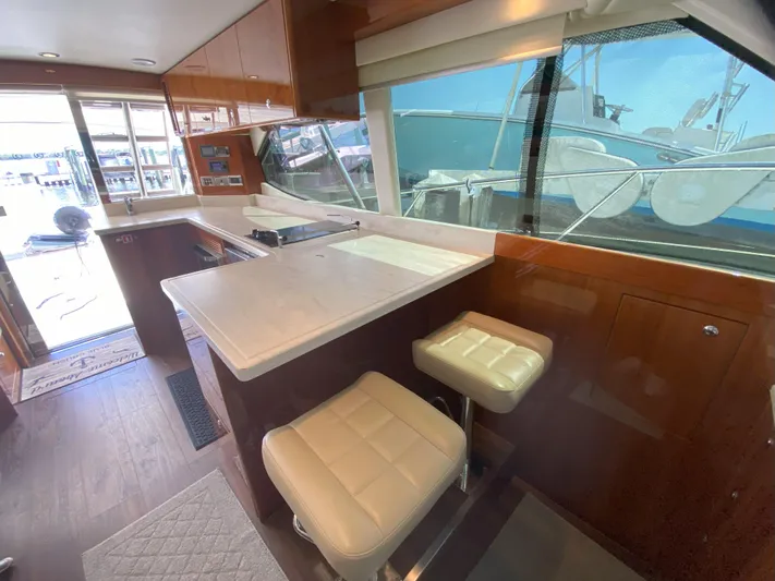  Yacht Photos Pics Interior of 2016 Riviera 43 Open Flybridge yacht with modern kitchen and seating.