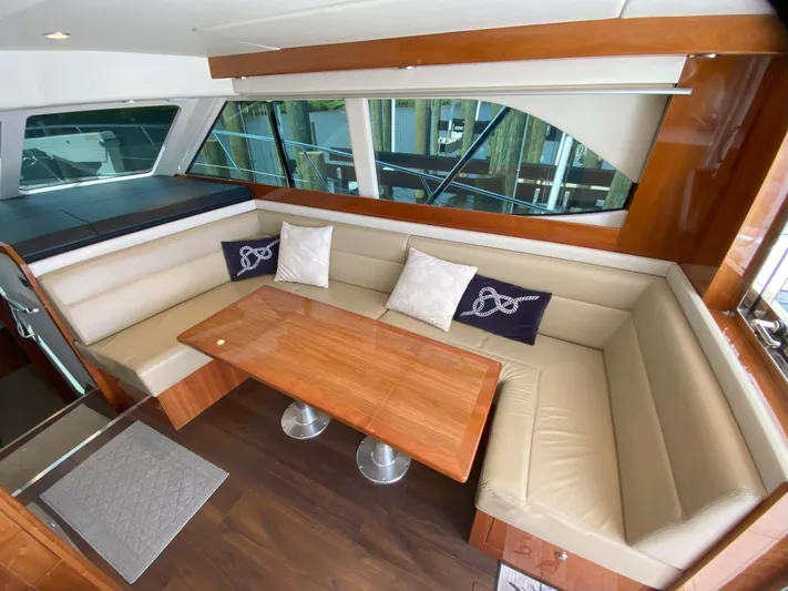  Yacht Photos Pics 2016 Riviera 43 Open Flybridge interior with beige leather seating and wooden table.