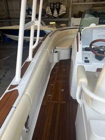  Yacht Photos Pics 2014 Chris-Craft Catalina 29 boat interior with wooden deck and white seating.