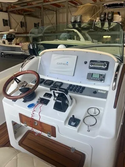  Yacht Photos Pics 2014 Chris-Craft Catalina 29 helm with Garmin navigation, wooden steering wheel, and control panel.