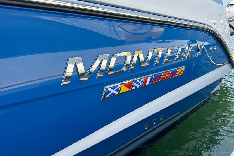 Relentless Yacht Photos Pics 2020 Monterey 355 Sport Yacht with nautical flags on blue hull.