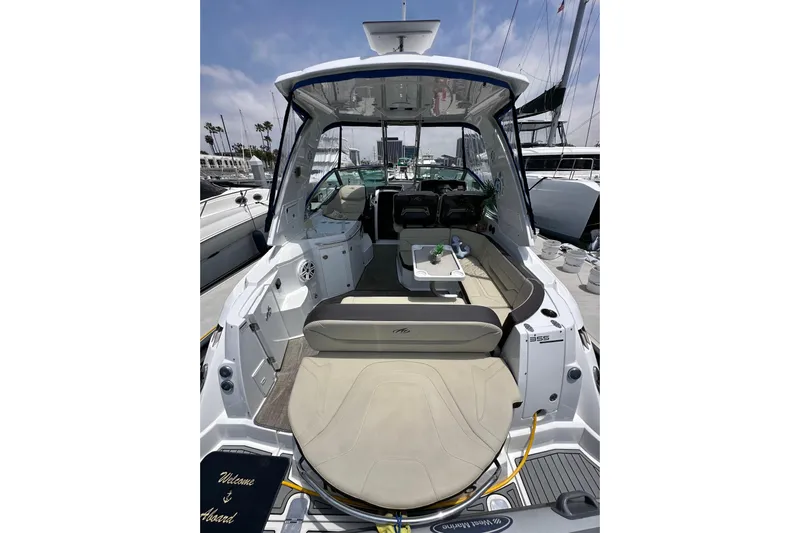 Relentless Yacht Photos Pics 2020 Monterey 355 Sport Yacht interior with seating and table, docked at marina.