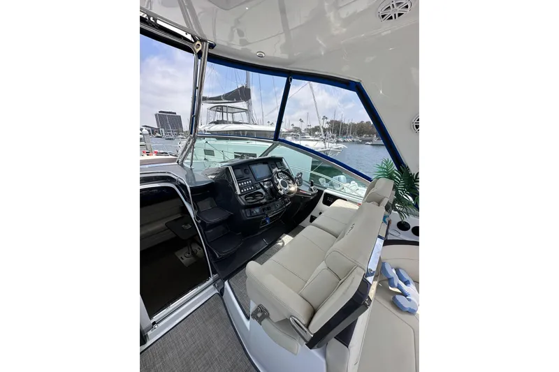 Relentless Yacht Photos Pics Interior of 2020 Monterey 355 Sport Yacht with helm and seating, docked at marina.