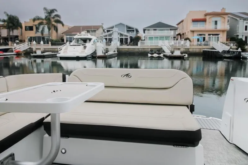Relentless Yacht Photos Pics 2020 Monterey 355 Sport Yacht interior with seating and table, docked in a marina.