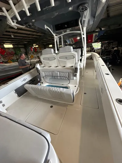Fountain 34 Cc Yacht Photos Pics 2023 Fountain 34 CC boat interior with seating and storage in a garage setting.