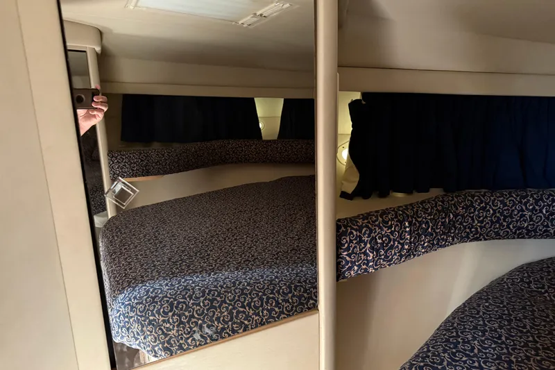  Yacht Photos Pics 1997 Sea Ray 370 Aft Cabin interior with patterned bedding and dark curtains.