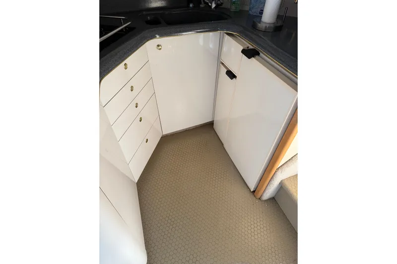  Yacht Photos Pics 1997 Sea Ray 370 Aft Cabin kitchen with white cabinets and hexagonal floor tiles.