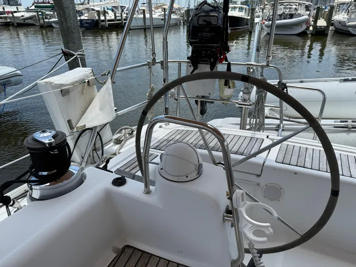 Passion Place Yacht Photos Pics Cockpit of a 2007 Beneteau 49 sailboat with steering wheel and marina view.
