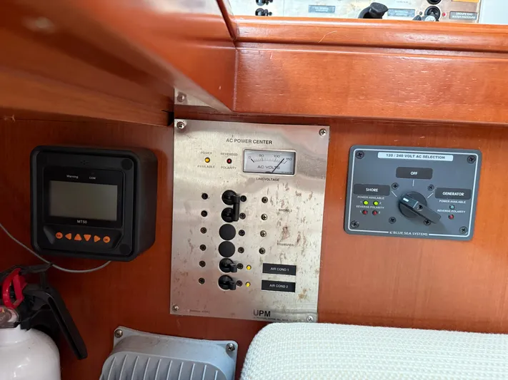 Passion Place Yacht Photos Pics Control panel of a 2007 Beneteau 49 yacht, featuring AC power and voltage selectors.