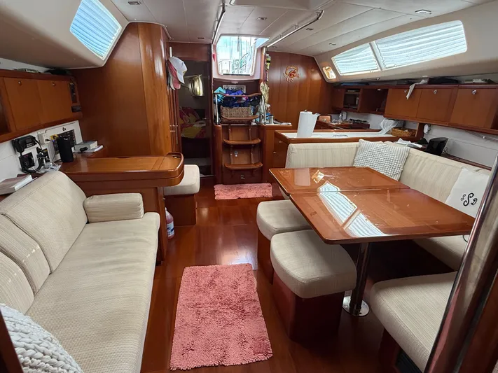 Passion Place Yacht Photos Pics Luxurious interior of a 2007 Beneteau 49 yacht with elegant wood finishes and cozy seating.