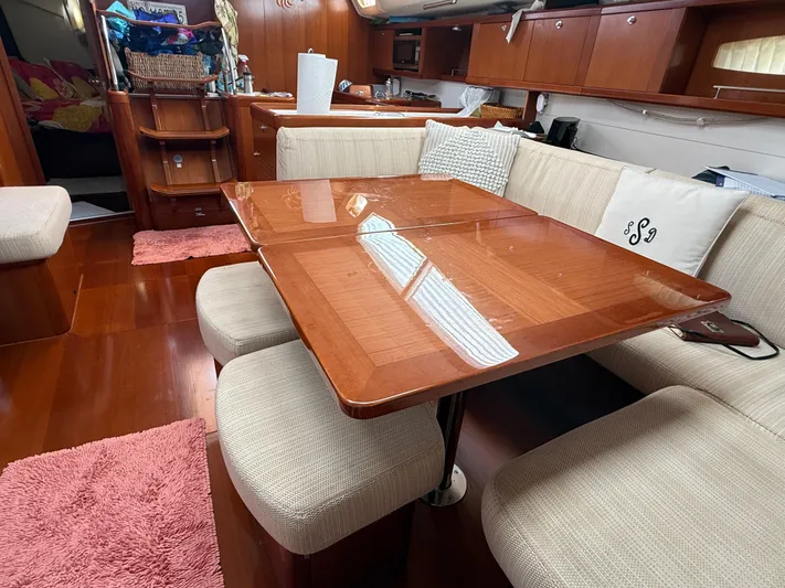 Passion Place Yacht Photos Pics Luxurious interior of a 2007 Beneteau 49 yacht with elegant wood finish and cozy seating.