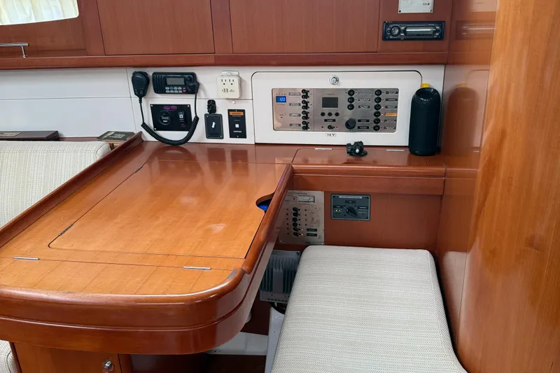 Passion Place Yacht Photos Pics Navigation station of a 2007 Beneteau 49 yacht with control panels and seating.