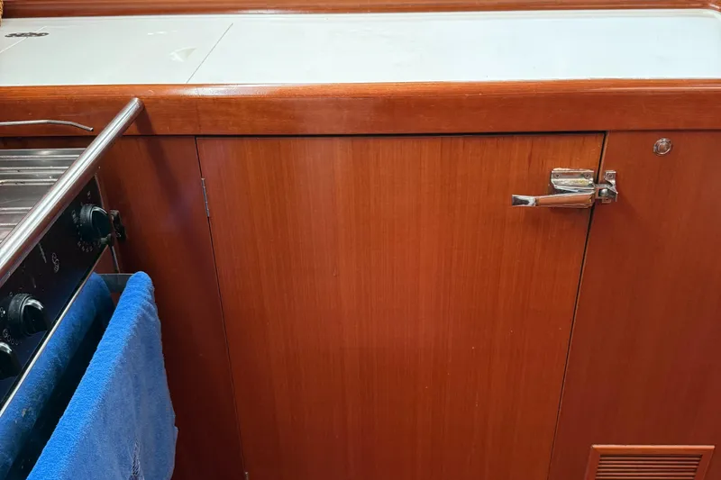 Passion Place Yacht Photos Pics Wooden kitchen cabinet and stove in a 2007 Beneteau 49 yacht galley.