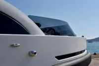 Custom 2023 Limo Tender yacht with sleek design and tinted windows, docked by the sea.