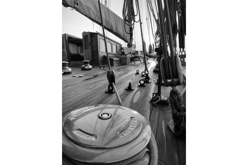 Invader Yacht Photos Pics Black and white view of 1905 Gaff Schooner deck, showcasing rigging and winch.