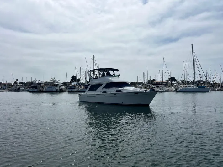  Yacht Photos Pics 1999 Bayliner 3988 Command Bridge Motoryacht docked in a marina under cloudy skies.
