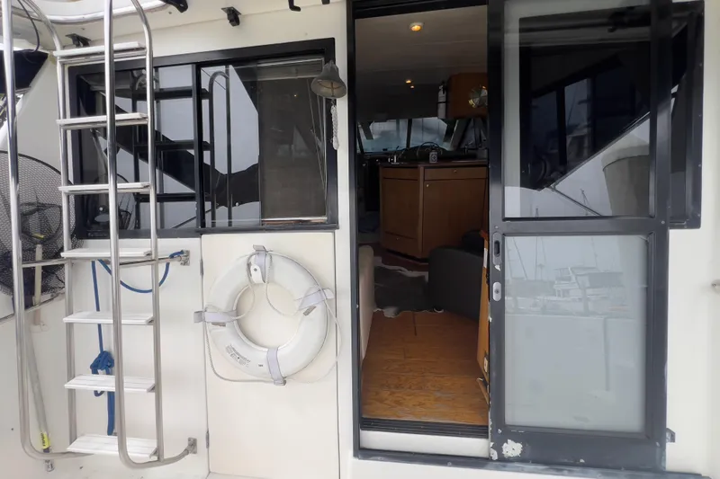  Yacht Photos Pics 1999 Bayliner 3988 Command Bridge Motoryacht with open cabin door and ladder.