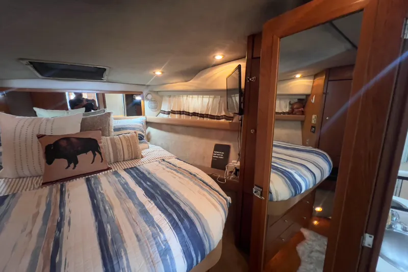  Yacht Photos Pics Cozy bedroom interior of 1999 Bayliner 3988 Command Bridge Motoryacht with striped bedding.