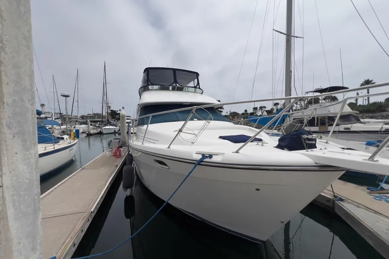  Yacht Photos Pics 1999 Bayliner 3988 Command Bridge Motoryacht docked at marina, side view.