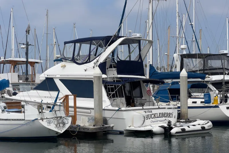  Yacht Photos Pics 1999 Bayliner 3988 Command Bridge Motoryacht docked in a marina with other boats.