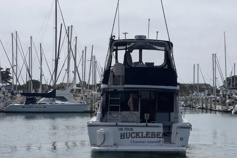  Yacht Photos Pics 1999 Bayliner 3988 Command Bridge Motoryacht docked in a marina with sailboats.