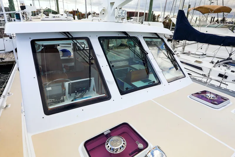  Yacht Photos Pics 2005 New England Boatworks Downeast Sedan with modern cockpit and marina view.