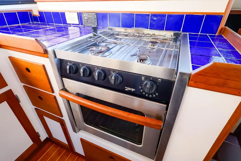  Yacht Photos Pics Stainless steel stove in 2005 New England Boatworks Downeast Sedan, with blue tiled countertop.