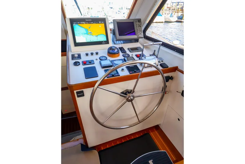  Yacht Photos Pics Helm of 2005 New England Boatworks Downeast Sedan with navigation equipment and steering wheel.