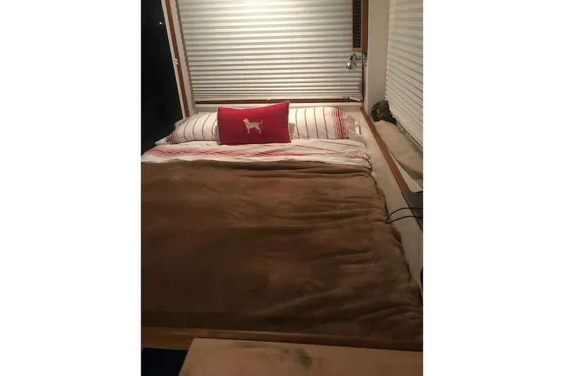  Yacht Photos Pics Cozy bedroom interior in 2005 New England Boatworks Downeast Sedan with striped bedding.