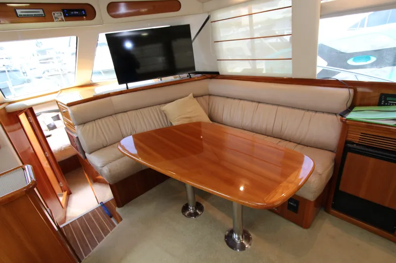  Yacht Photos Pics Luxurious interior of 2005 Riviera 46 Convertible Sportfisher with plush seating and wooden table.