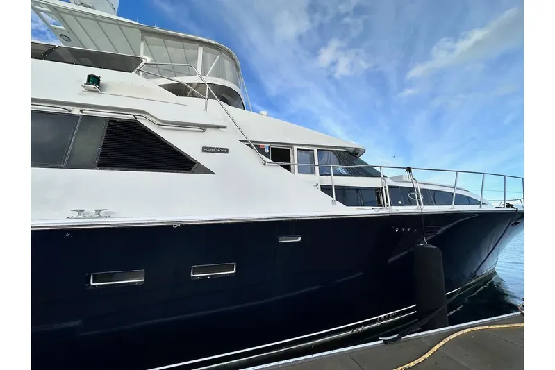 First Home Yacht Photos Pics 1988 Cheoy Lee 92 yacht docked, showcasing sleek design and elegant structure against a blue sky.