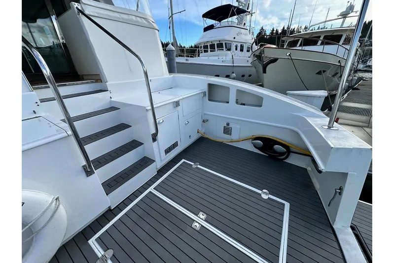 First Home Yacht Photos Pics 1988 Cheoy Lee 92 yacht deck with stairs and storage, docked at marina.