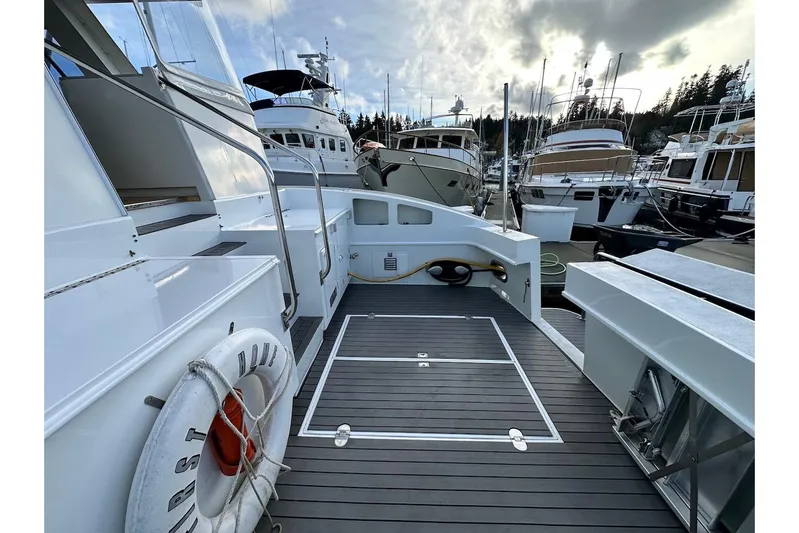 First Home Yacht Photos Pics 1988 Cheoy Lee 92 yacht deck with lifebuoy, docked among other boats.
