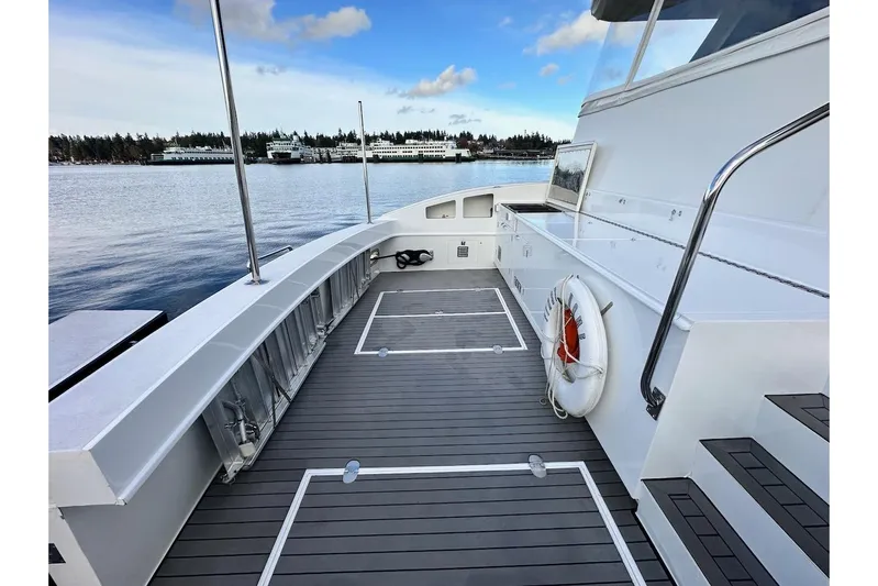 First Home Yacht Photos Pics Deck view of 1988 Cheoy Lee 92 yacht with life preserver and scenic waterfront.