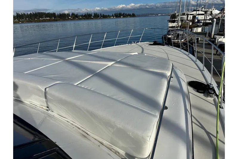 First Home Yacht Photos Pics 1988 Cheoy Lee 92 yacht deck with white cushions, docked by calm waters.