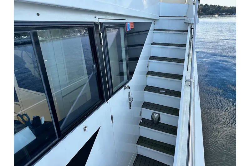 First Home Yacht Photos Pics Staircase on 1988 Cheoy Lee 92 yacht, overlooking serene water view.